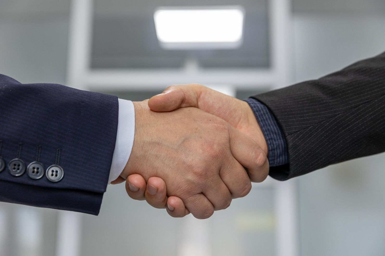 Industrial partnership handshake at a copper manufacturing facility